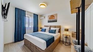 A hotel room with a large bed, a bedside table with a lamp, a wardrobe, and a window with curtains. - Villa Antea by Villas Guide (Vela Luka)