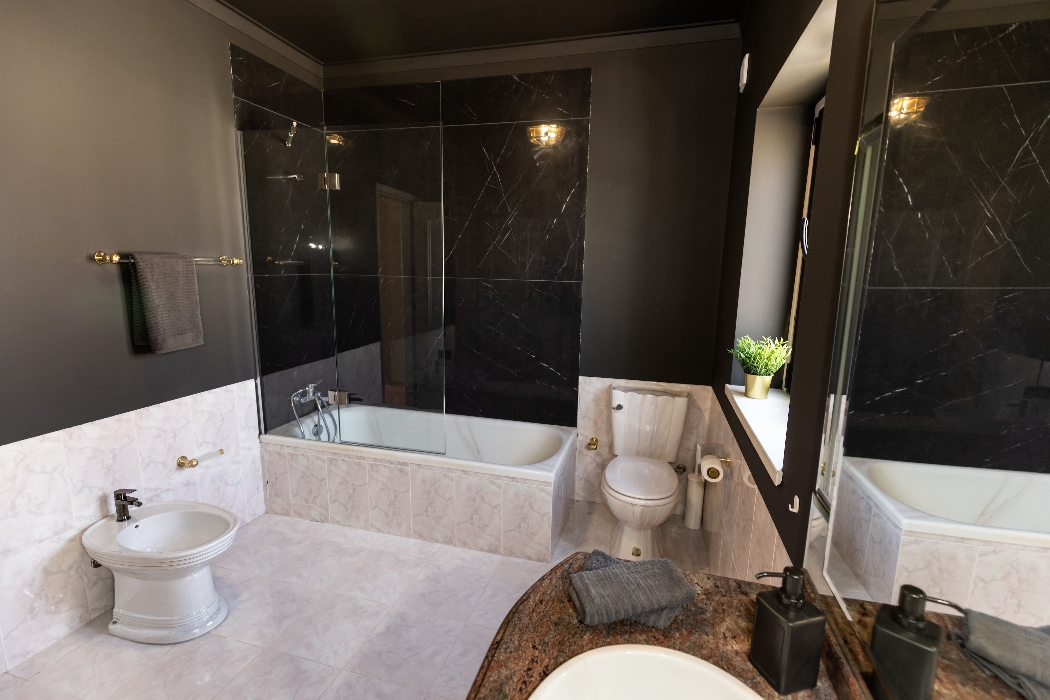Un baño moderno con una bañera independiente, un lavabo pedestal y un inodoro.