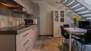 Eine moderne Küche mit Mikrowelle, Schränken und einem Essbereich mit Tisch und Stühlen.