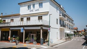 A white building with the sign "HOTEL LAURA" on the front.