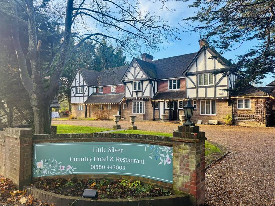 Een klassiek Tudor-gebouw met een bord voor Little Silver Country Hotel & Restaurant.