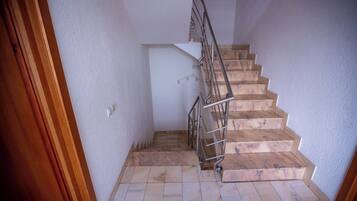 A staircase with wooden steps and metal railings, leading to an upper floor.