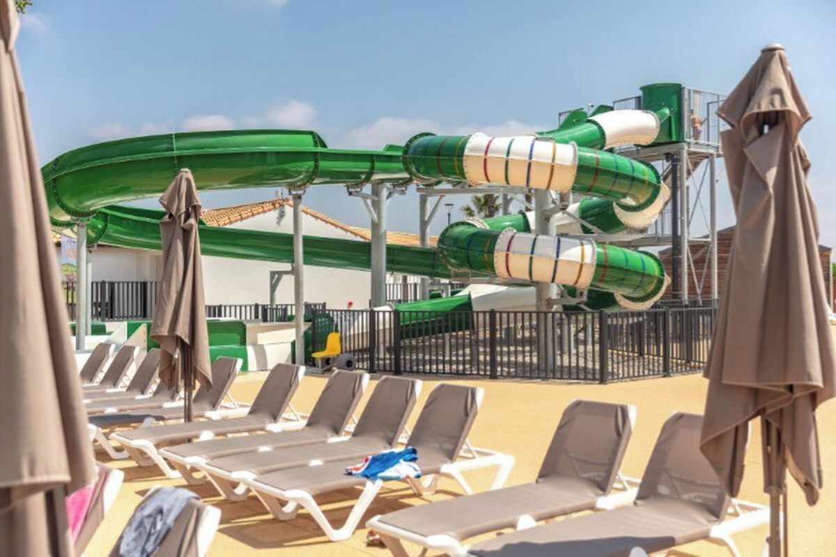 Ein Wasserpark mit mehreren Wasserrutschen und Liegestühlen.
