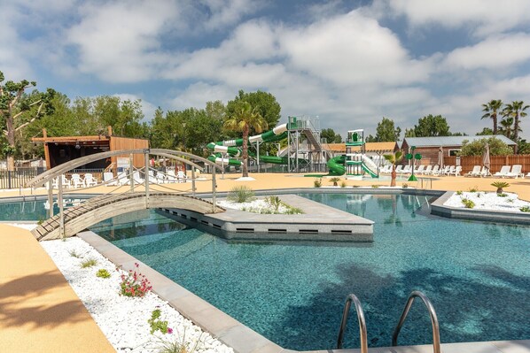 Una piscina al aire libre de temporada, sillones reclinables de piscina