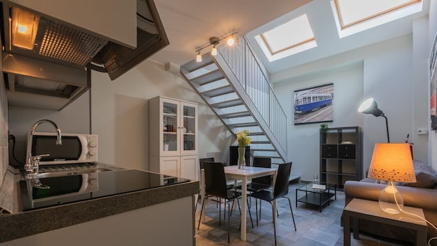 A compact living space with a kitchen, dining area, and seating area. - Loft Tramvai by Wonderful Italy (Turin)