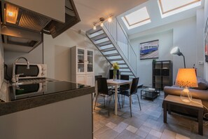 A compact living space with a kitchen, dining area, and seating area. - Loft Tramvai by Wonderful Italy (Turin)