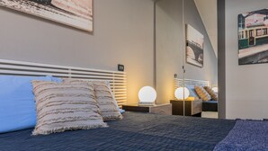 A modern hotel room with a large bed, two bedside tables, and a mirror. - Loft Tramvai by Wonderful Italy (Turin)