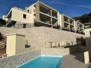 A modern hotel with a pool, multiple balconies, and a stone facade. - Prestige view 103 by Avecoeur (Èze)