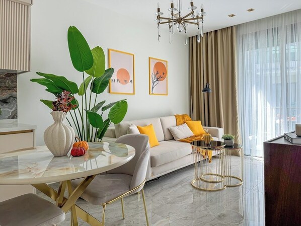 Un salon moderne avec un canapé, une table basse et un coin repas doté d’une table en marbre.