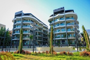 Un immeuble d’appartements moderne doté de nombreux balcons, portant l’inscription « BestHome 37 ».