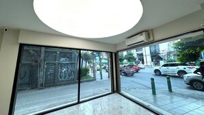 Una habitación con amplios ventanales, una lámpara de techo y vistas a la calle.