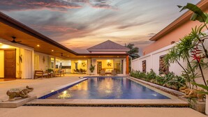 A swimming pool with a sunset view, a covered patio area, and a dining space. - Villa Hemi 2BR Modern Thai Style (Choeng Thale)