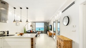 A modern kitchen with a large island, pendant lights, and a view of the ocean. - Haifa Beachside Stay by Sea N' Rent (Haifa)