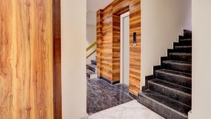 A modern staircase with wooden paneling and marble steps. - Super Collection O Dehradun Central (Dehradun)