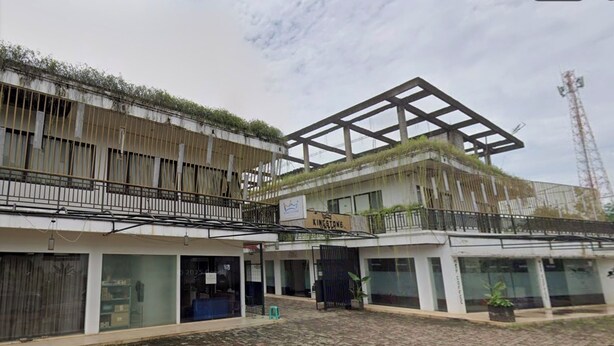 A building with a modern architectural design, featuring a mix of glass and metal structures. - King Stone Hotel By ARBA (Bekasi)