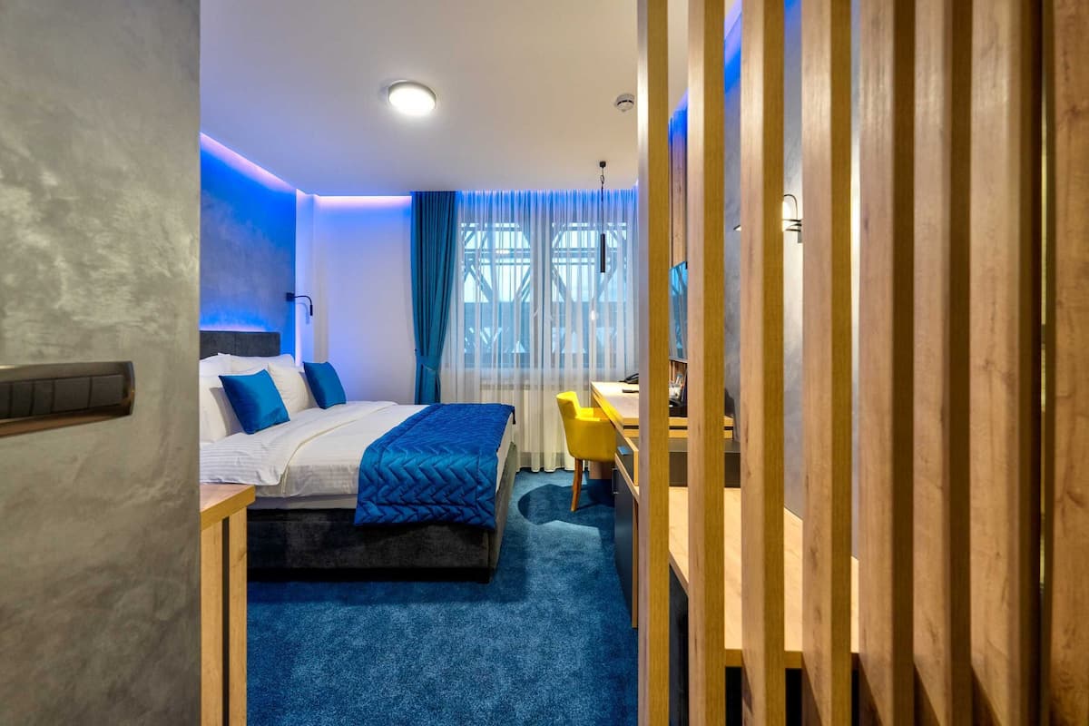 Una habitación de hotel moderna con una cama, un escritorio y una silla.