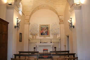 An interior with arched brick ceilings, a central altar with a painting, and pews arranged for seating. - Holiday Home 'Villa Riggia - La Masseria' with Wi-Fi and Air Conditioning (Nardò)
