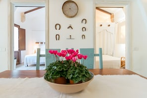 A room with a wooden table, a bowl of flowers, and a wall with horse-shaped decorations. - Holiday Home 'Villa Riggia - La Masseria' with Wi-Fi and Air Conditioning (Nardò)