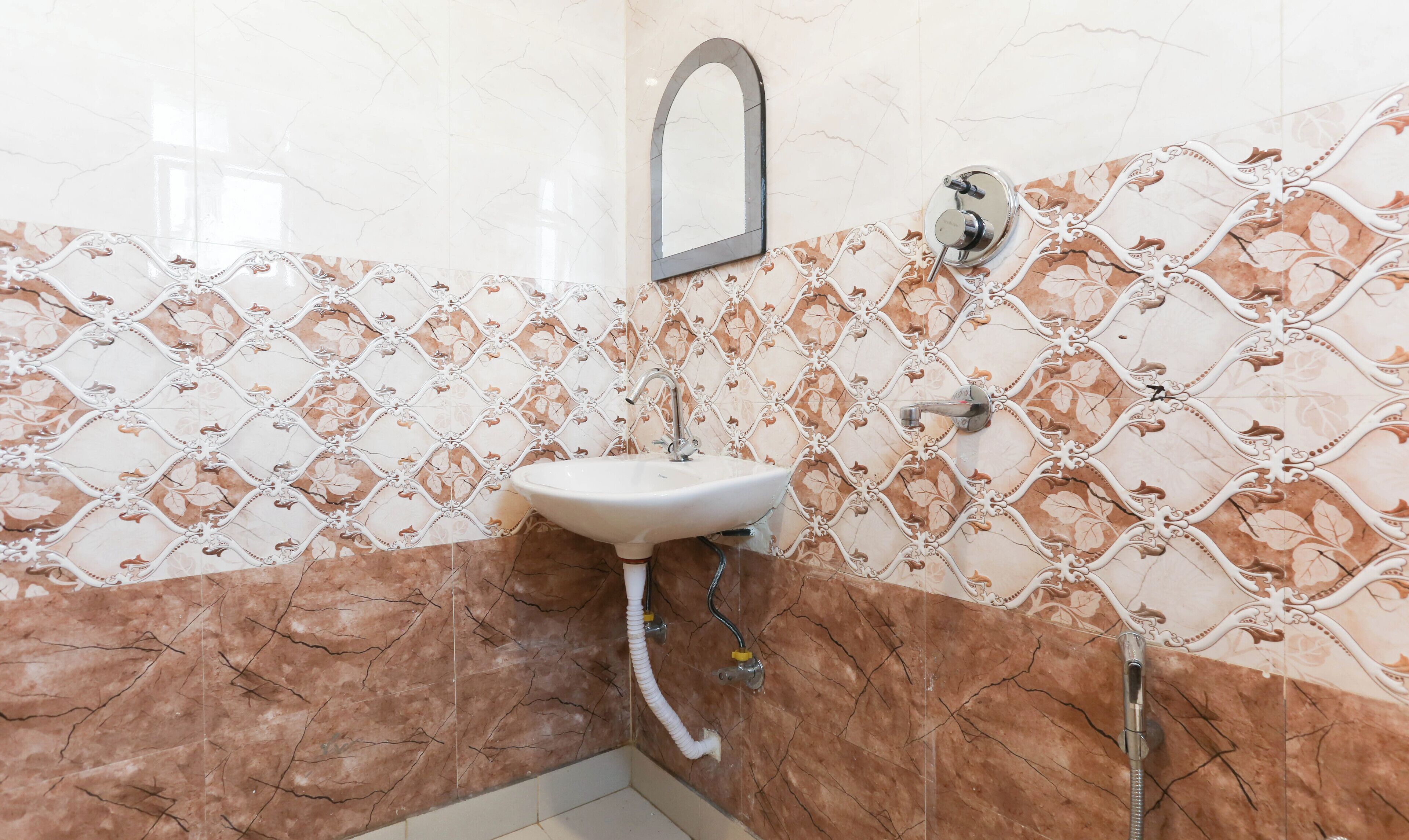 Un baño con lavamanos, espejo y ducha.