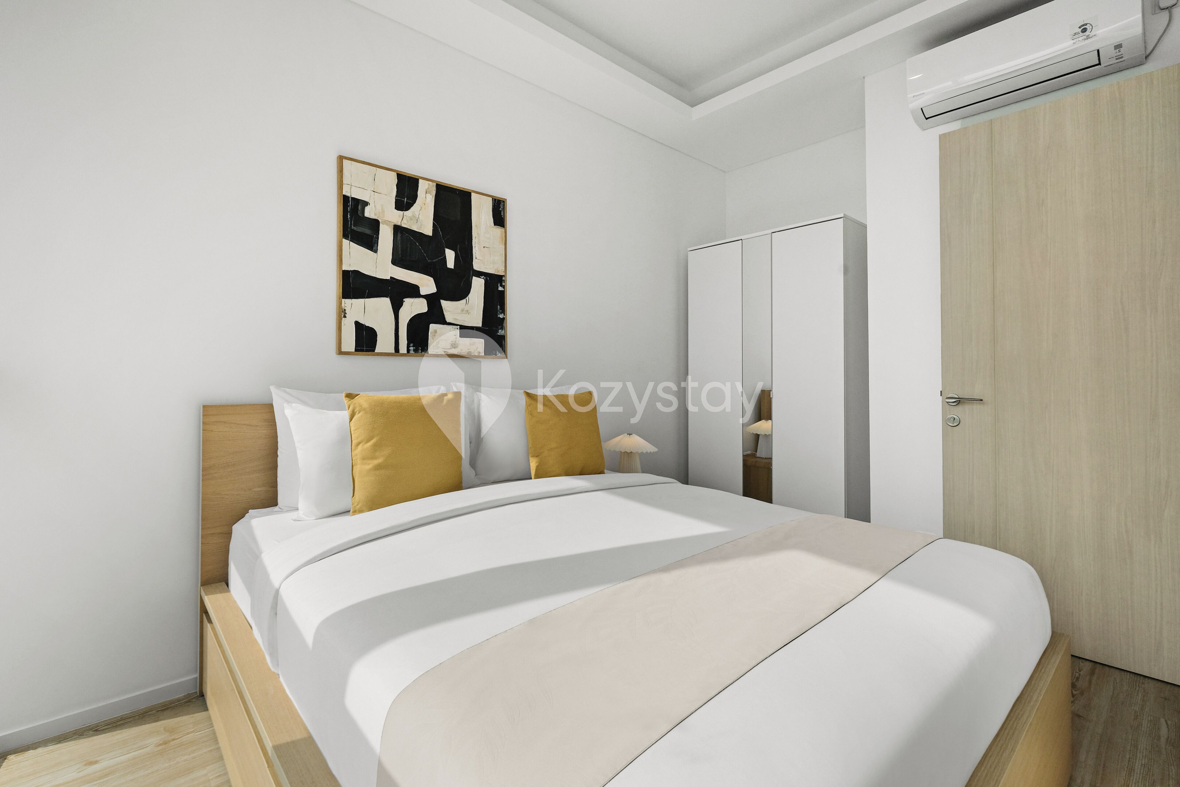 A modern bedroom with a bed, a wardrobe, and a wall-mounted air conditioner.
