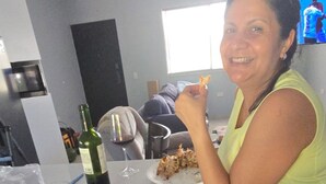 A dining table with plates of food, a wine bottle, and a TV in the background. - Your Dream Escape to Nature & Fun at Villa Palmeras in Playa Juan Hombron (El Chiru)
