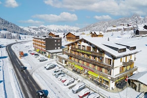 A hotel with multiple floors, a ski lift, and a parking area.