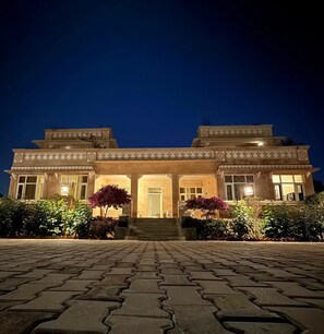 A two-story building with a symmetrical facade, large windows, and a central entrance with steps leading up to it. - The Bagheera Retreat (Pushkar)