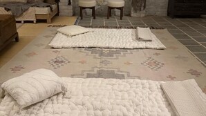 A cozy room with a bed, a sofa, and two stools. - The Bagheera Retreat (Pushkar)