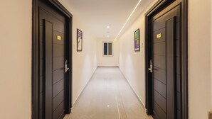 A hallway with two black doors, each marked with a number. - Treebo SS Residency Gandhi Nagar (Vijayawada)