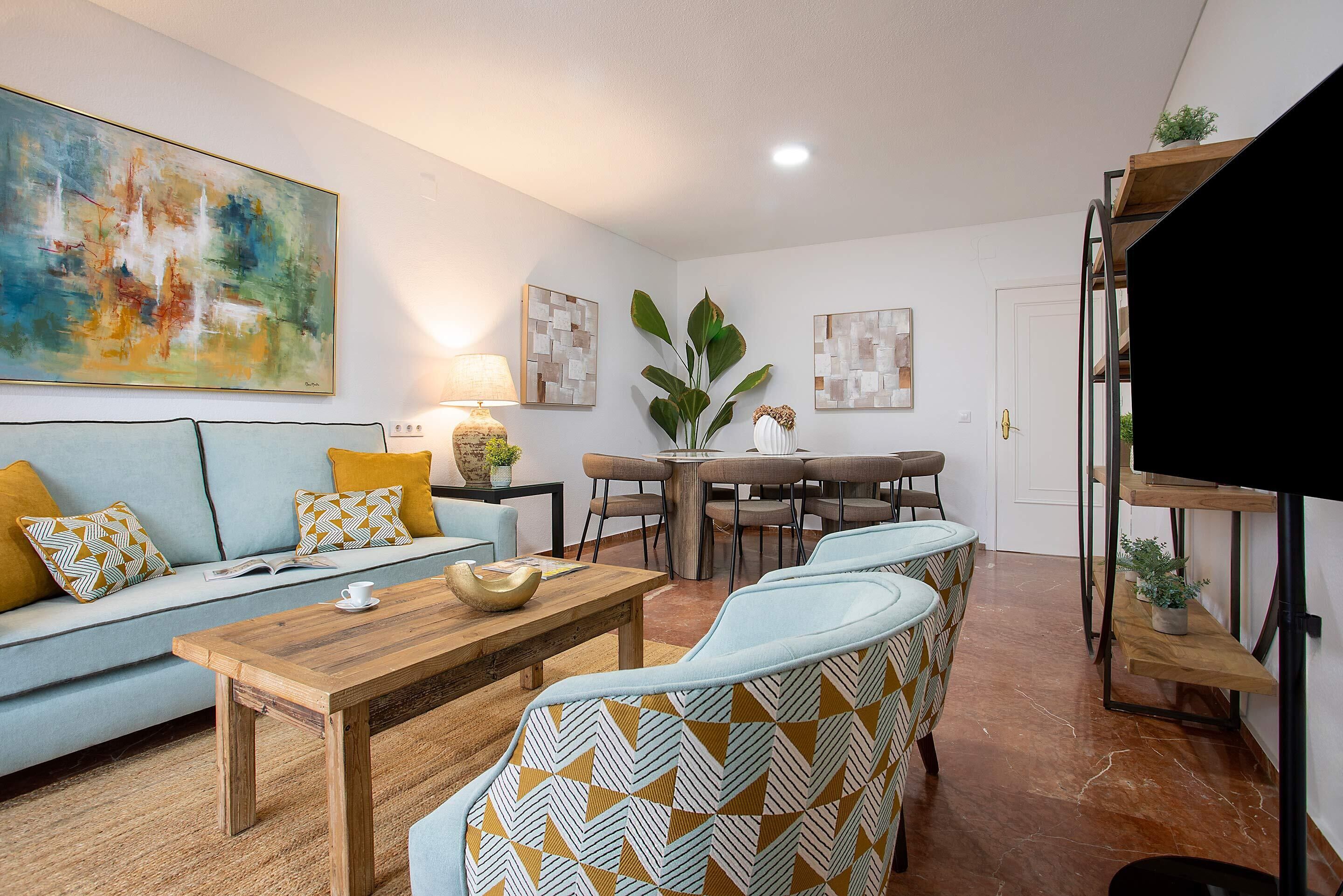 Una sala moderna con un sofá, una mesa de centro y sillas estampadas.