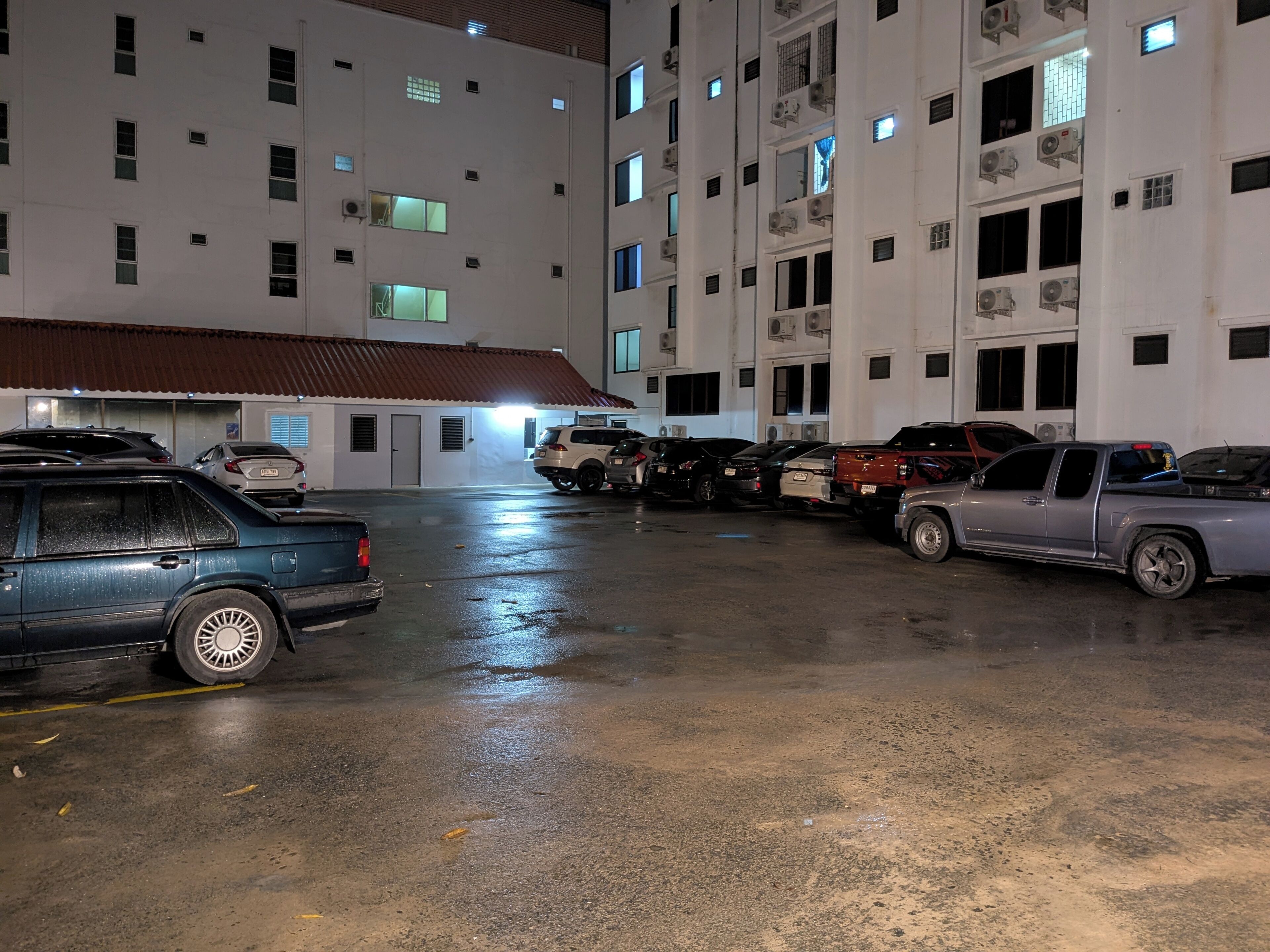A multi-story parking garage with several parked vehicles, including SUVs and a pickup truck.