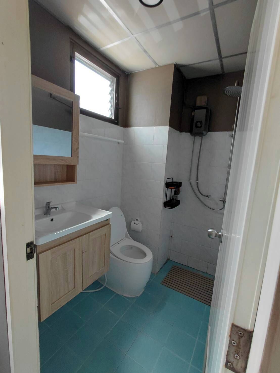 A compact bathroom with a toilet, sink, and shower.