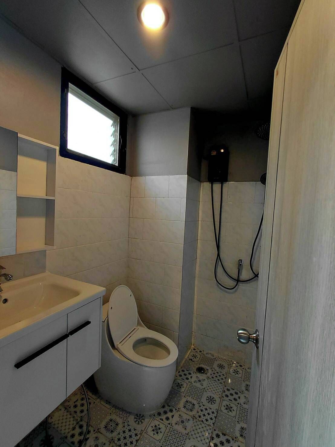Ein kleines Badezimmer mit Toilette, Waschbecken und Dusche.