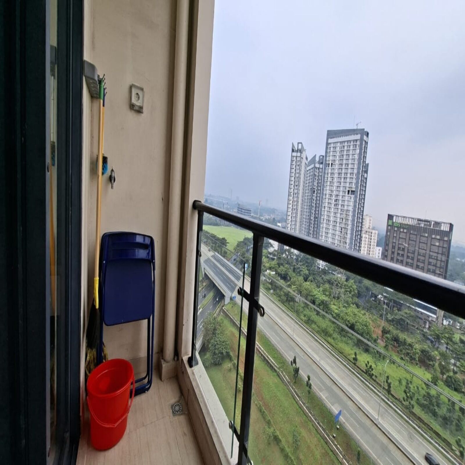 A balcony with a view of a highway and high-rise buildings.