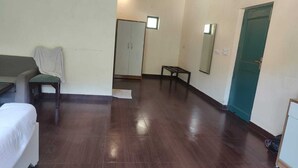A room with a bed, a chair, a small table, a wardrobe, and a door. - Shiva solace by Sam Valley (Bhimtal)