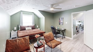 A bedroom with a bed, two chairs, a desk, and a ceiling fan. - Golf, Hike & Explore! ‘Tranquil Oasis’ in Cameron (Cameron)