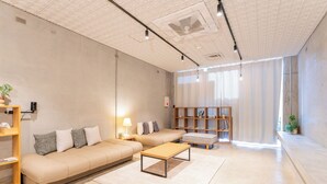 Un salon moderne avec un canapé, une table basse et une bibliothèque.