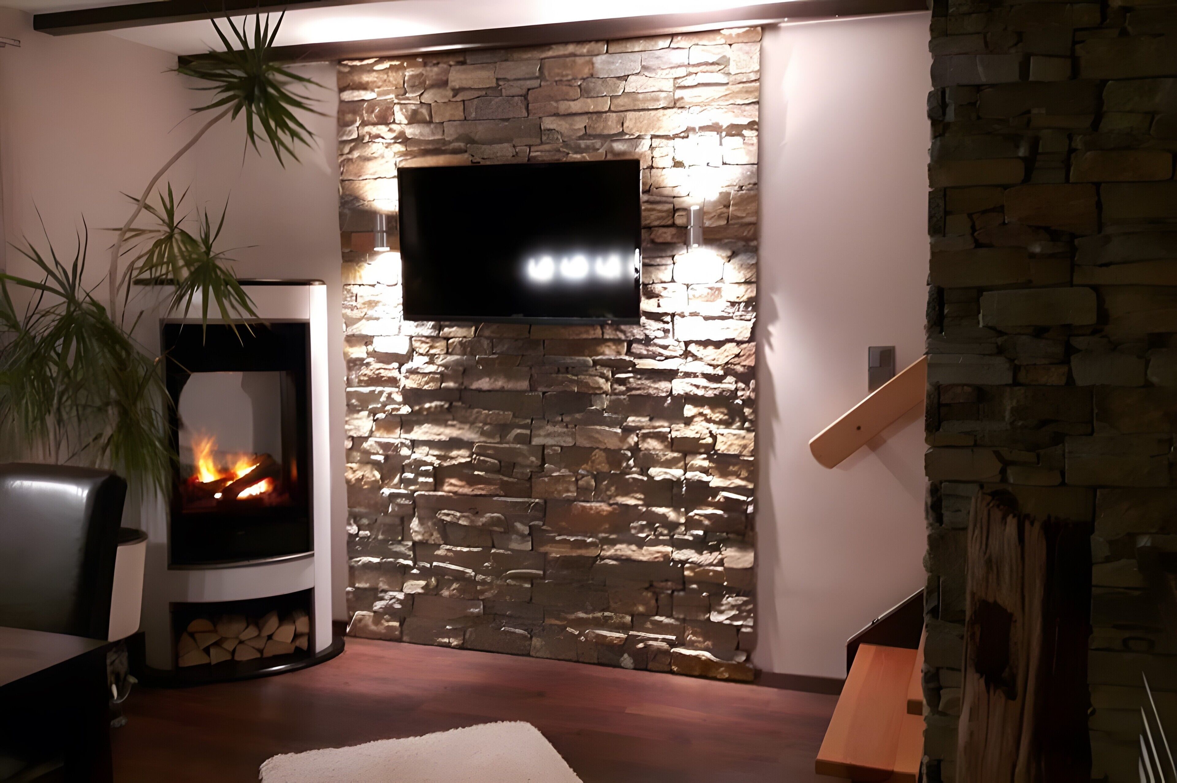 Una sala de estar con pared de piedra, un televisor de pantalla plana, chimenea con leña y un banco de madera.