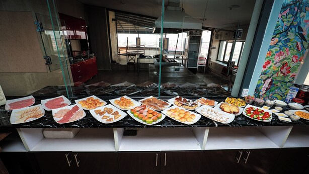 A buffet with various food items and a view of the dining area.