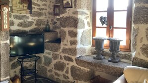 A stone-walled room with a television, a window with a heart-shaped decoration, and a thermostat on the wall. - La Boulantie 5-bedroom chalet in quaint Florentin-la-Capelle (Florentin-la-Capelle)