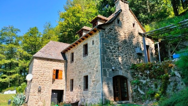 A stone house with a sloped roof, a chimney, and a small porch. - La Boulantie 5-bedroom chalet in quaint Florentin-la-Capelle (Florentin-la-Capelle)