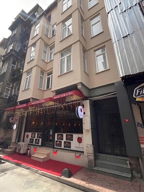 A building with a storefront labeled 'MAGIC BOX SUSHI' and a sign indicating room number 19. - One-Bedroom Apartment in Taksim - No: 11 (Beyoglu)