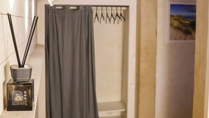A bathroom with a shower, a towel rack, a picture on the wall, and a wooden ceiling. - Casa Pannella (Vittorio Veneto)