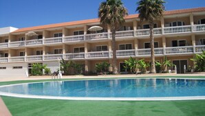 A hotel with a swimming pool, multiple balconies, and palm trees. - LA BELLA CAROLINA EN COSTA DEL SILENCIO (Costa del Silencio)