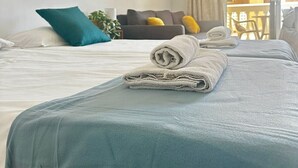 A neatly made bed with a folded towel on top, a grey bedspread, and a grey headboard. - LA BELLA CAROLINA EN COSTA DEL SILENCIO (Costa del Silencio)