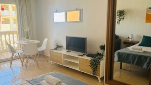 A hotel room with two beds, a TV, a desk, and a chair. - LA BELLA CAROLINA EN COSTA DEL SILENCIO (Costa del Silencio)