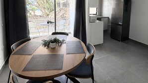 A modern kitchen with a refrigerator and a dining area with a table and chairs. - Coastal Retreats Beach & Ocean View Playa Arena (Santiago del Teide)