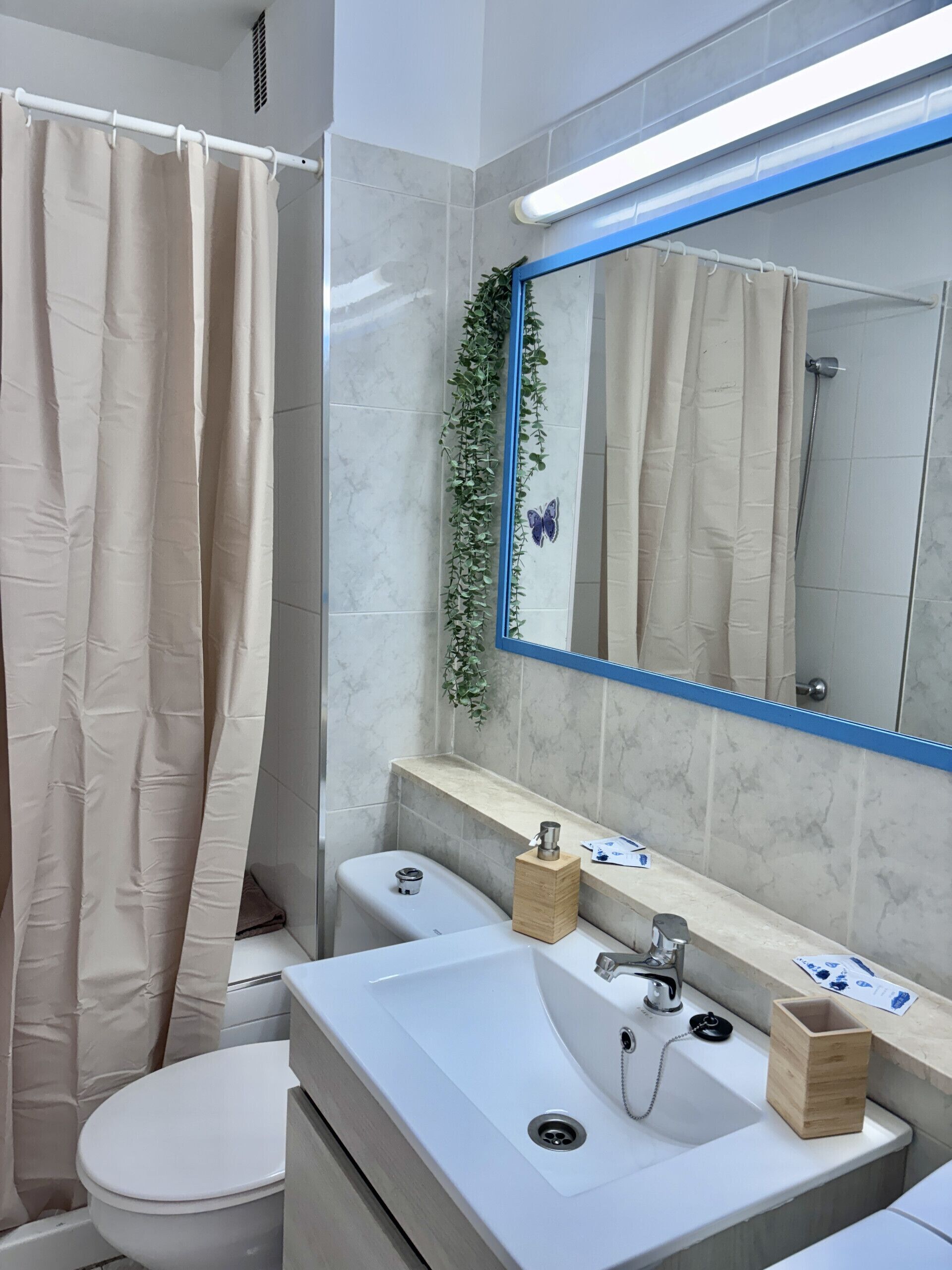Une salle de bain moderne équipée de toilettes, d’un lavabo et d’un rideau de douche.