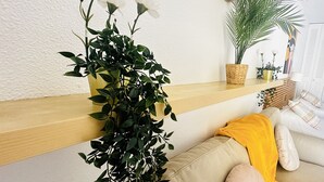 A living room with a sofa, a plant, and a wall clock. - Sunny Views Los Cristianos (Los Cristianos)