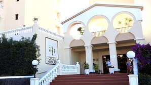 A hotel entrance with a staircase, a sign reading "CASLE HOUSE," and a balcony with plants. - Sunny Views Los Cristianos (Los Cristianos)